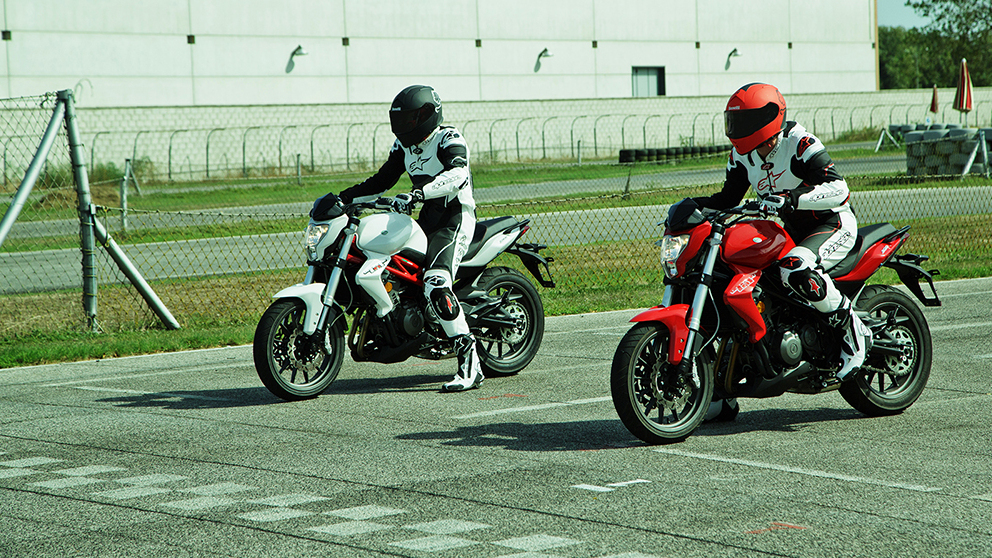 نمایه ای از دو موتورسیکلت با راکبانشون یکی سفیدرنگ و یکی قرمز رنگ که میخواهند با هم مسابقه دهند